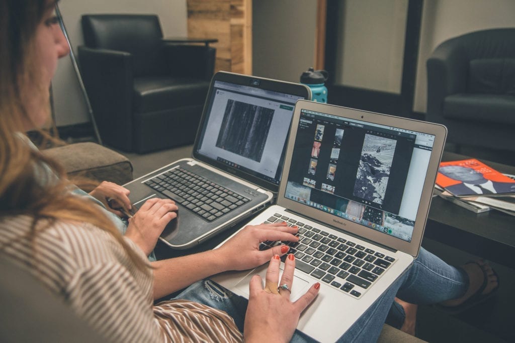 woman doing creative work on her laptop on her lap