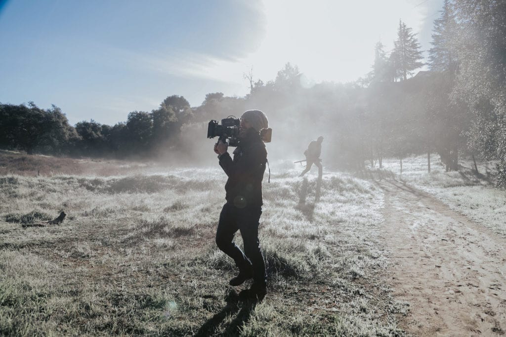 man with camera films in the wilderness outside