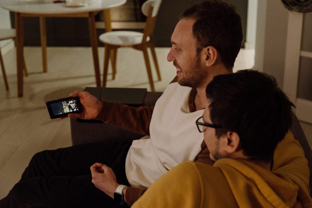 two friends watching a video on a smartphone
