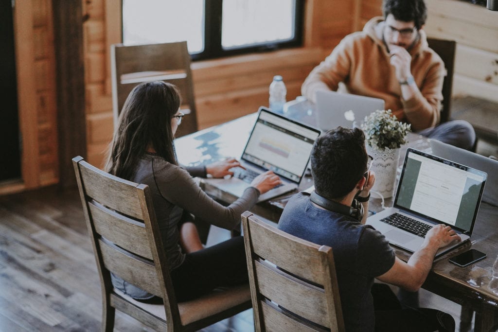 three people working on their laptops