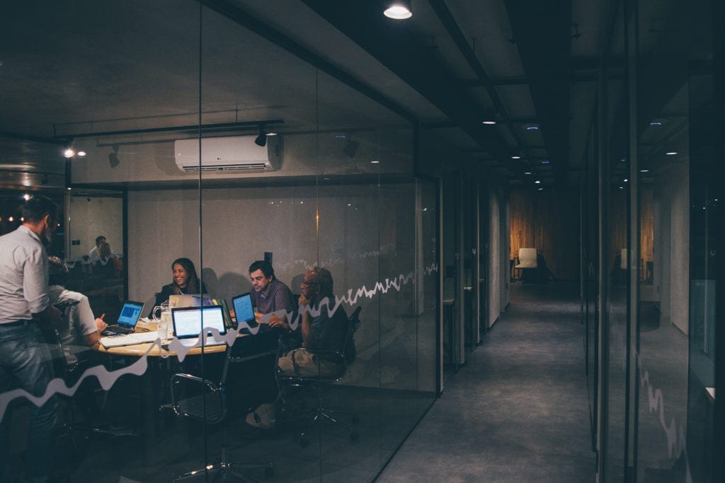 people sitting in a modern conference room with glass walls