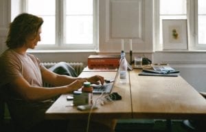 man sitting at desk with laptop