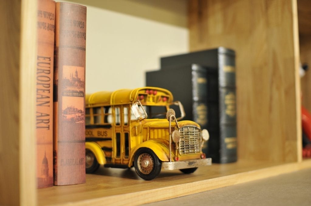 school bus toy on bookshelf