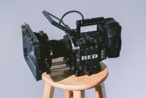 red camera sitting on wooden stool