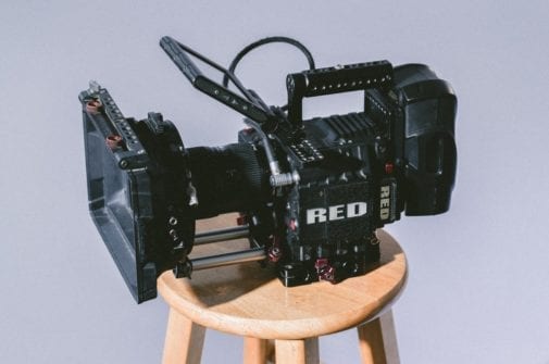red camera sitting on wooden stool