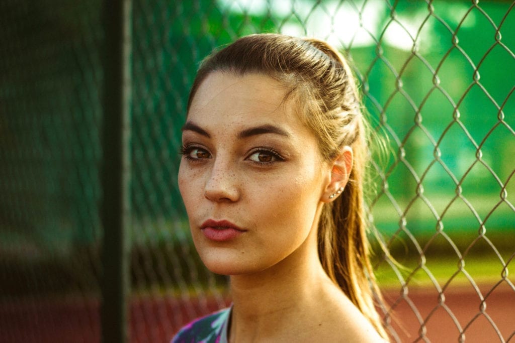 actress standing in front of fence