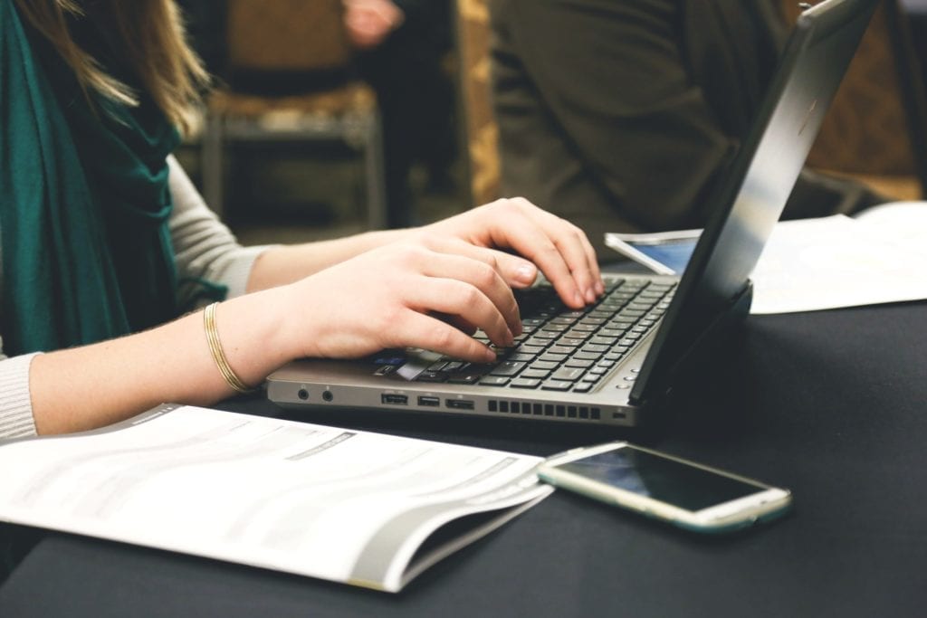 woman taking screenplay notes at laptop