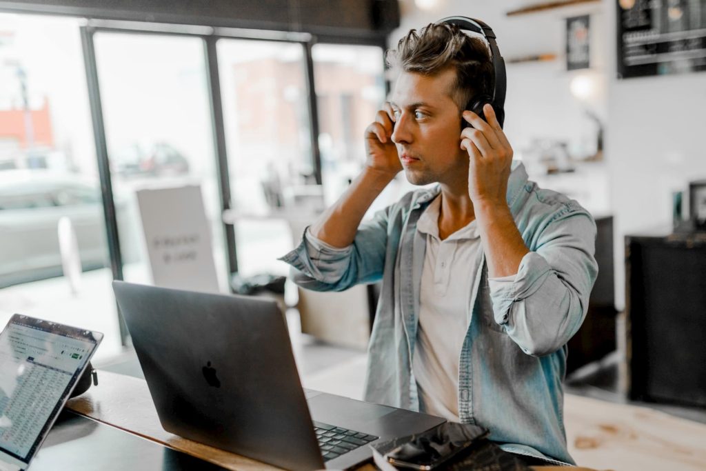 digital producer sitting at laptop with headphones