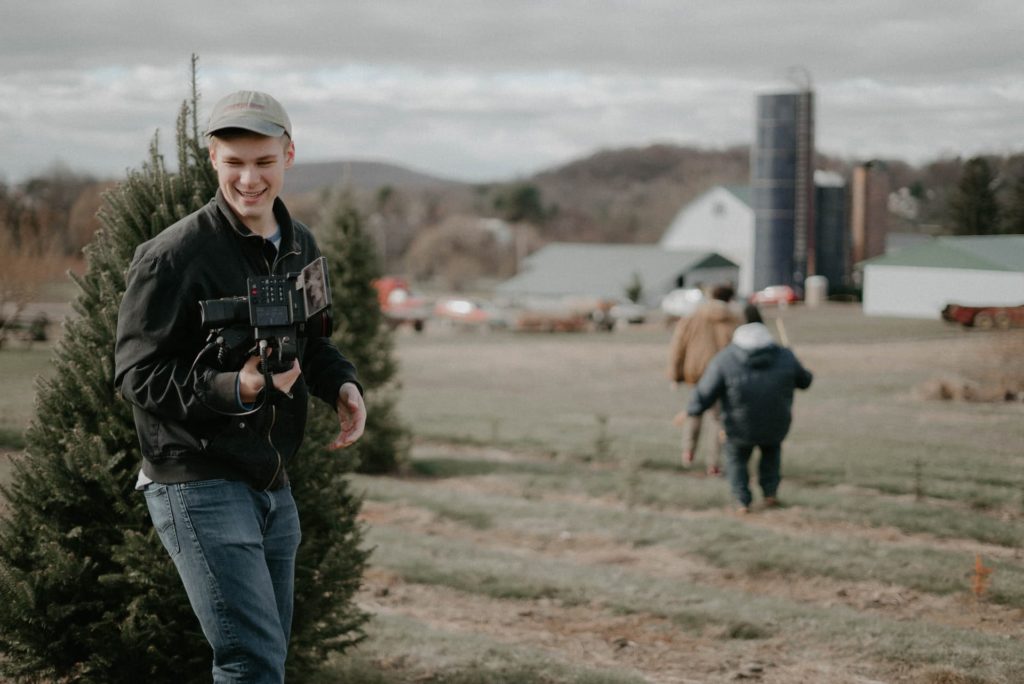 filmmaker exterior shot film producer in front of christmas tree