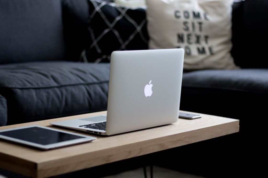 macbook iphone and ipad on table near couch