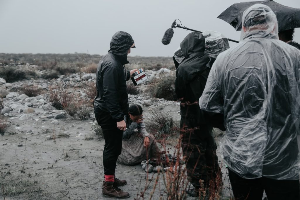 producer wearing rain jacket poncho on film set