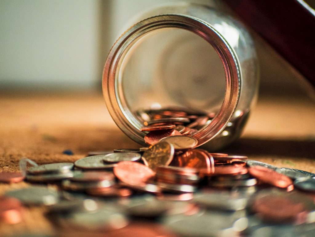 jar of coins spilling out on table