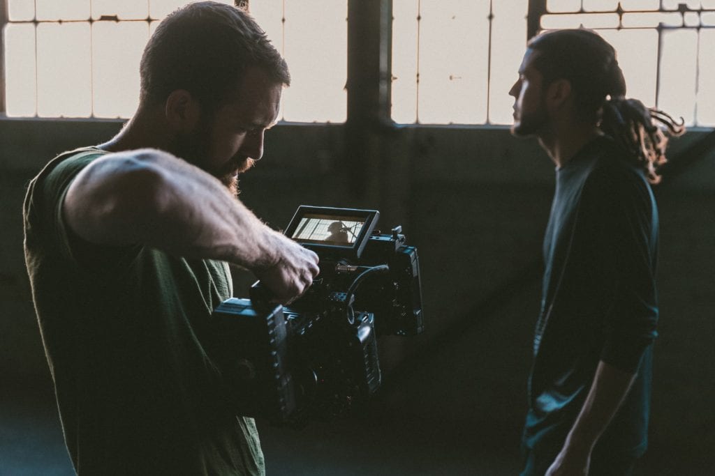 Man with camera finding the perfect angle from which to film his actor film fund.