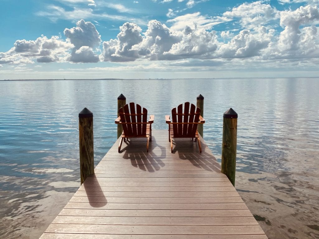 Adirondack chairs set up on a pier film fund.