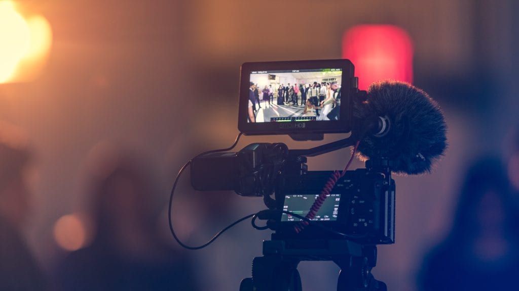 Video monitor displays wedding guests dancing on the dance floor film fund.