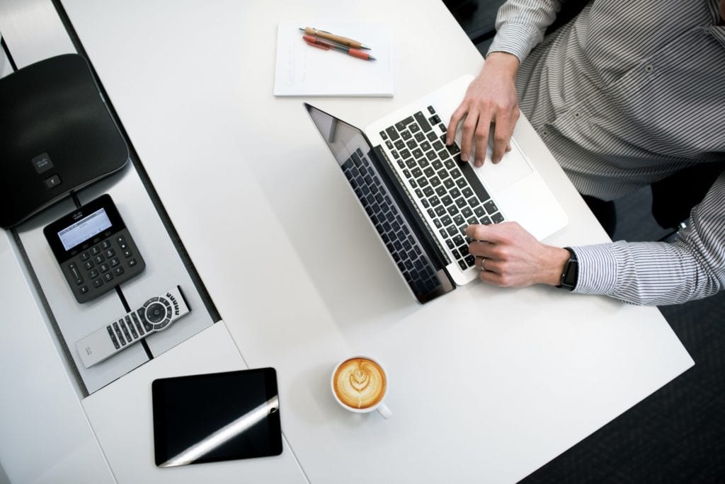 Man sitting in front of laptop performing administrative tasks film fund