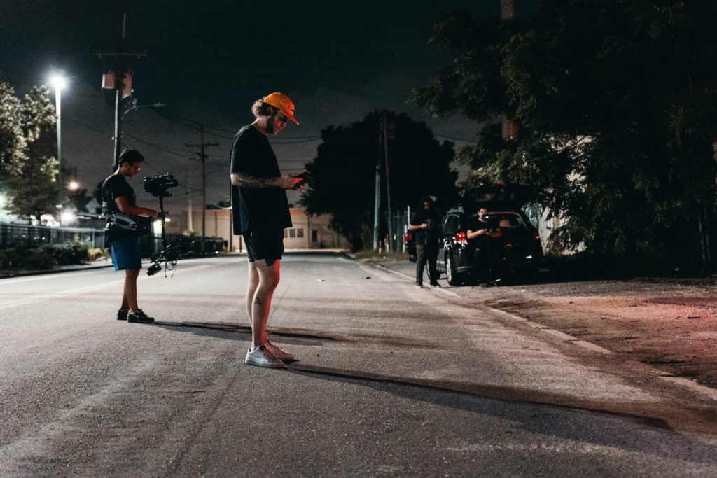 men standing in the street capturing film footage the film fund