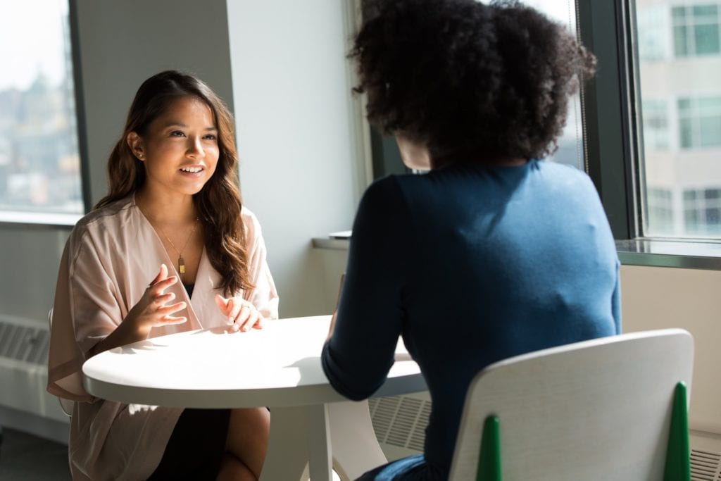 two women sitting at a table for an Internet the film fund