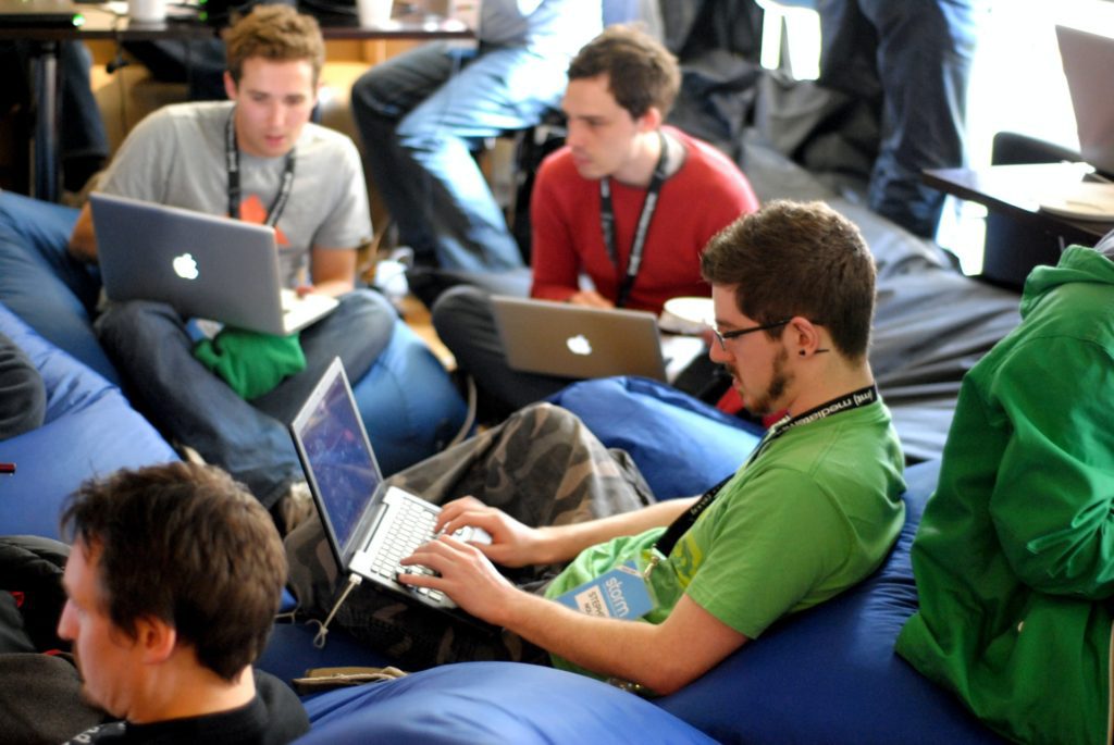 group of men sitting on their computers conversing the film fund