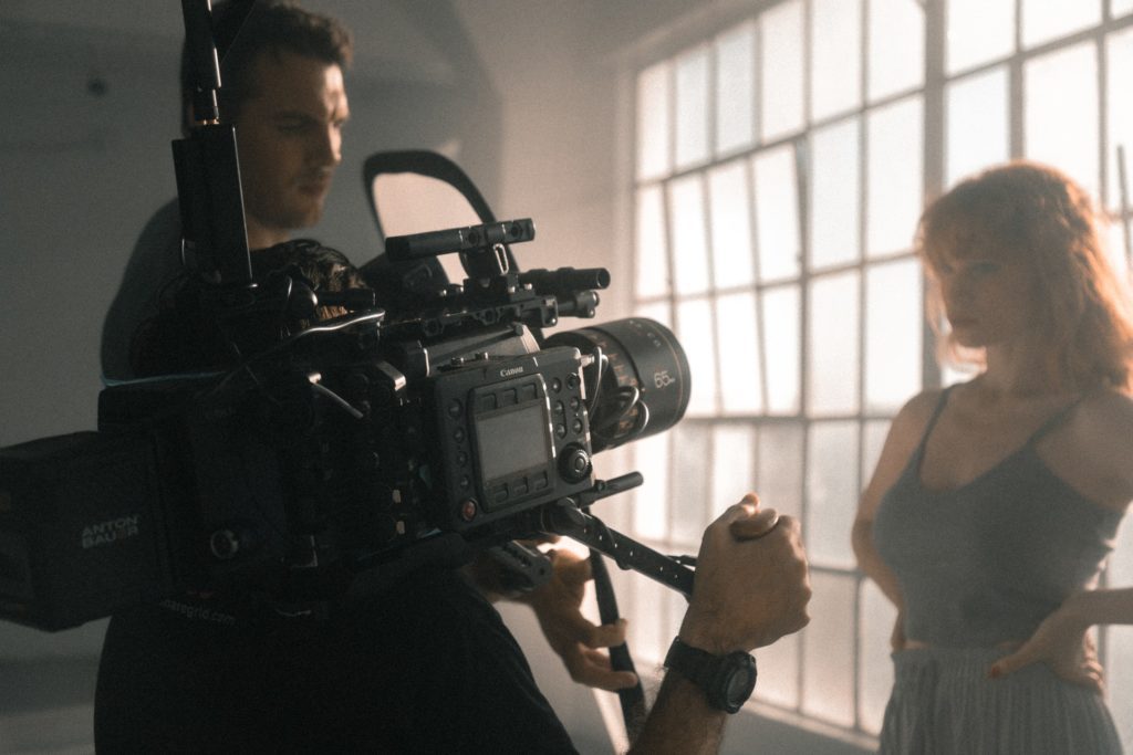 two men working to adjust the camera as they film a woman the film fund