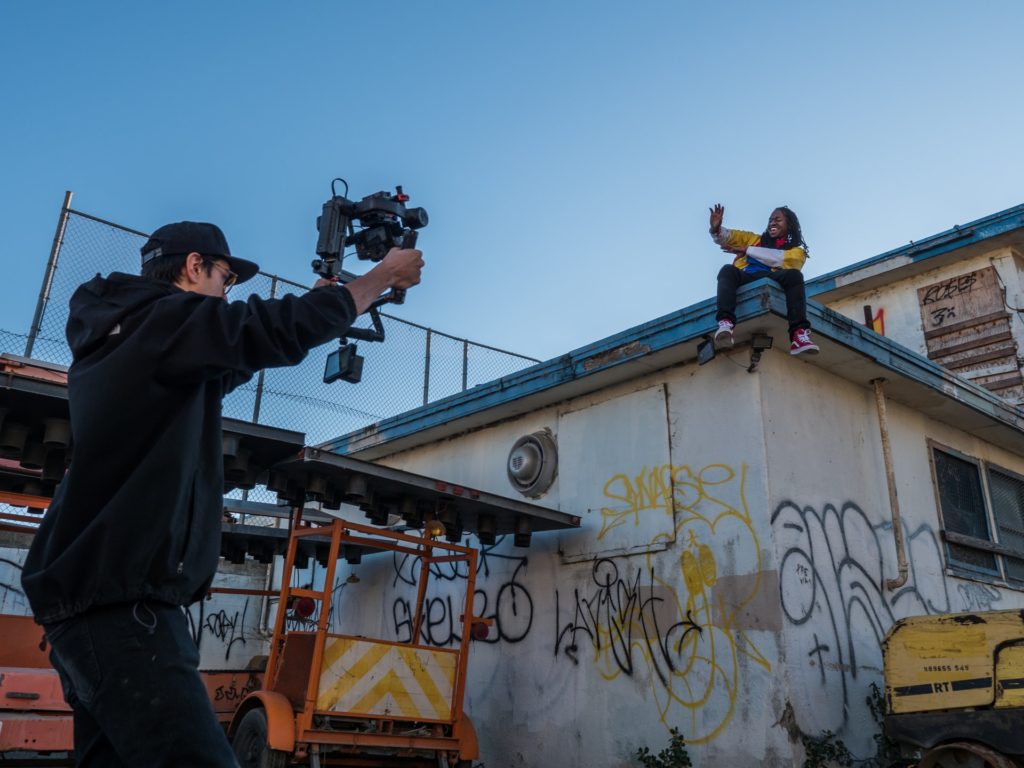 man filming person sitting on roof the film fund