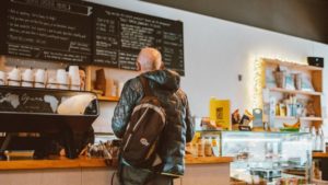 A man waiting in line at a coffee shop