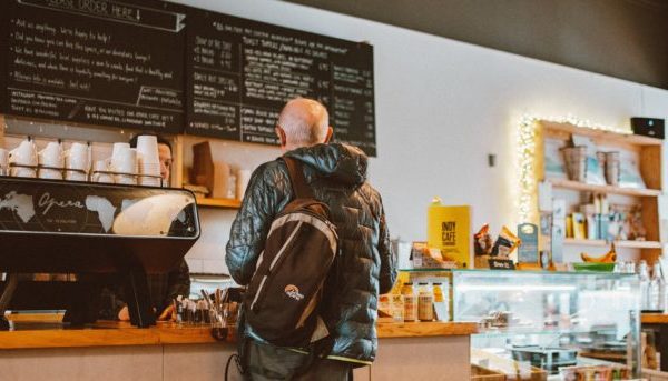 A man waiting in line at a coffee shop