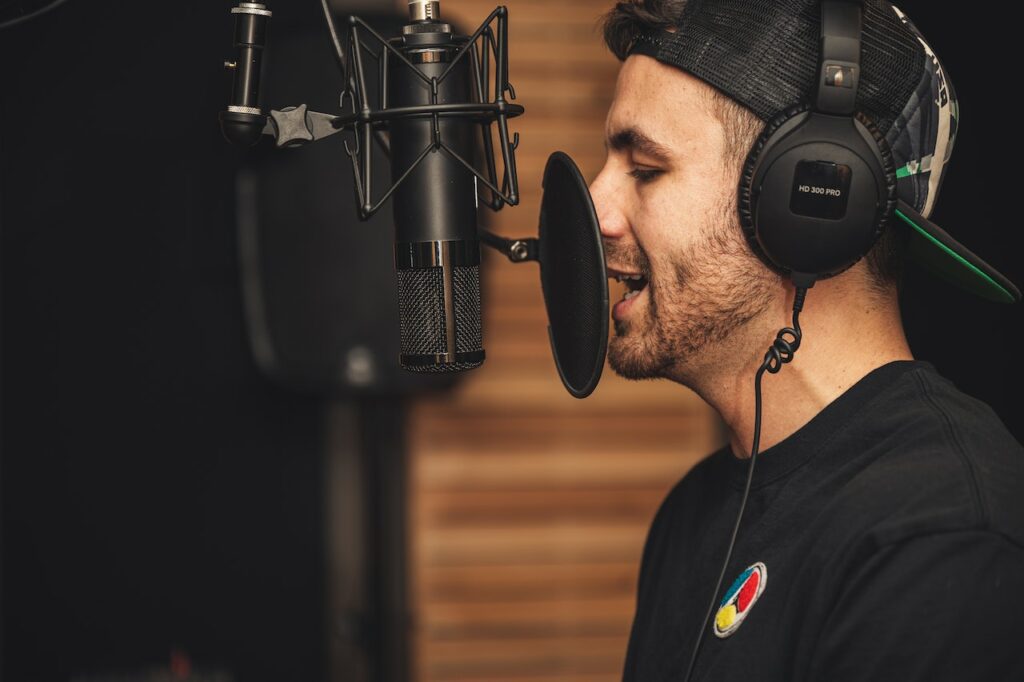 A man speaking into a microphone in a studio.